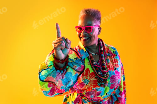 Preview: Fashionable senior woman pointing up creating positive idea