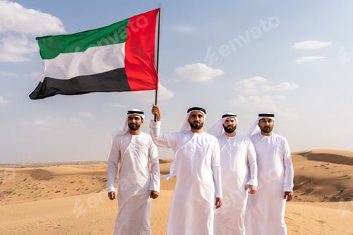 Preview: Emirati men holding uae flag in desert expressing patriotism