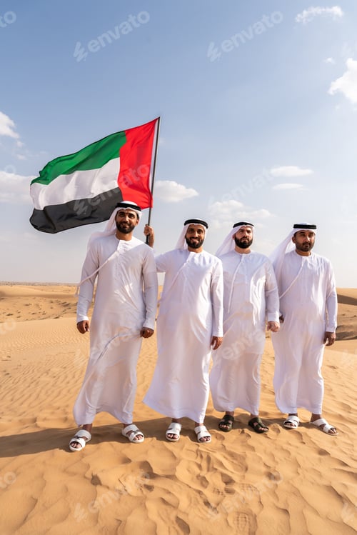 Preview: Emirati men holding uae flag in desert