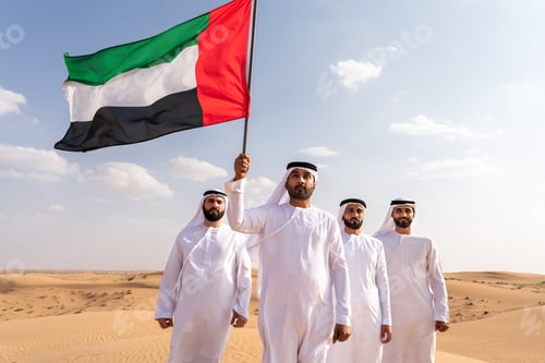 Preview: Emirati men holding flag showing patriotism in desert