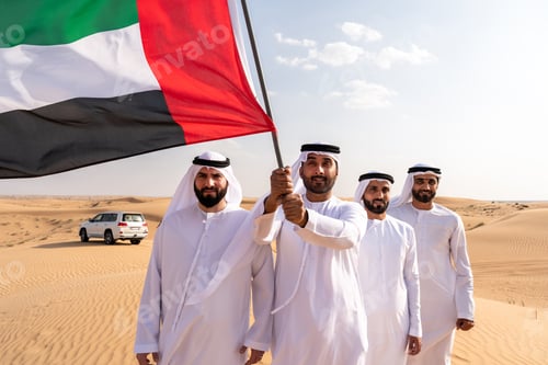 Preview: Emirati men carrying uae flag in dubai desert celebrating national day