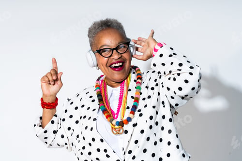 Preview: Senior woman enjoying music, dancing with headphones, vibrant style