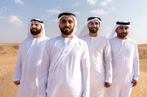 Preview: Middle eastern men wearing traditional emirati clothing bonding in desert