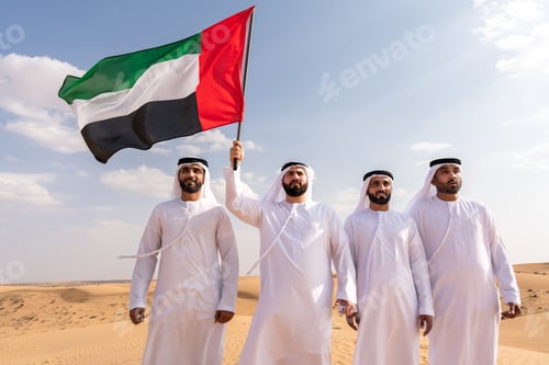 Preview: Emirati friends holding united arab emirates flag in desert