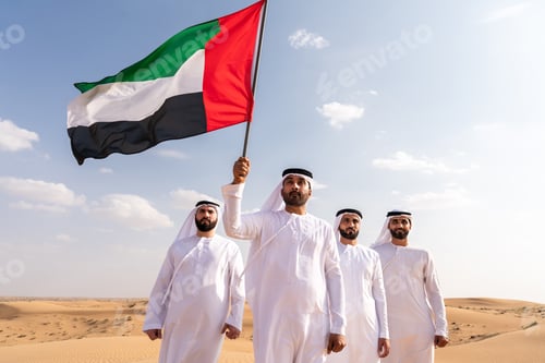 Preview: Emirati men holding uae flag in desert expressing patriotism