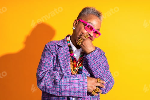 Preview: Confident mature woman wearing pink sunglasses and colorful jewelry