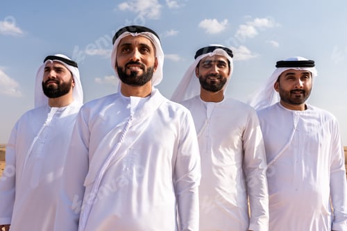 Preview: Arab men wearing traditional emirati clothing bonding in desert