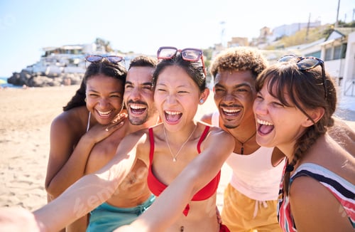 Preview: Multiracial group of happy young people on the beach taking a fun selfie in swimwear for share