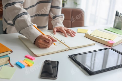 Preview: Professional freelancer analyzing and taking notes during remote work session.