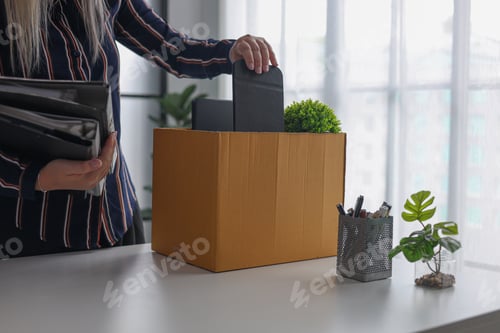 Preview: Employee Packing Personal Items in Box After Being Fired or Resigning from Corporate job.