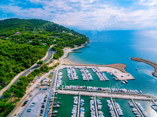 Preview: Aerial View of a Serene Marina Surrounded by Lush Green Hills and Calm Blue Waters