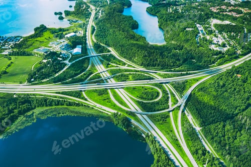 Preview: Aerial View of Interconnected Roadways Surrounded by Lush Green Landscapes and Water Bodies