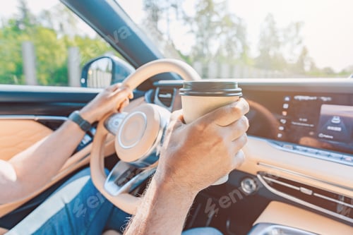Preview: Driver Holds Coffee While Navigating a Modern Car's Dashboard with Sunlight Streaming In