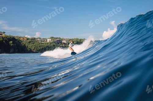 Preview: Surfer girl rides crashing ocean wave in sunny day in Bali