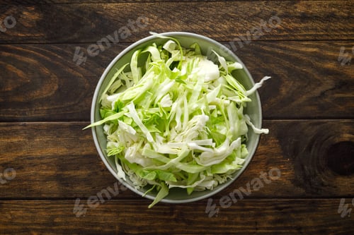 Preview: Freshly Shredded Green Cabbage in a Bowl on a Dark Wood Table