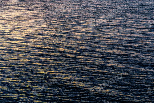 Preview: Sea water surface at sunset. Rippled ocean texture with golden light reflections.