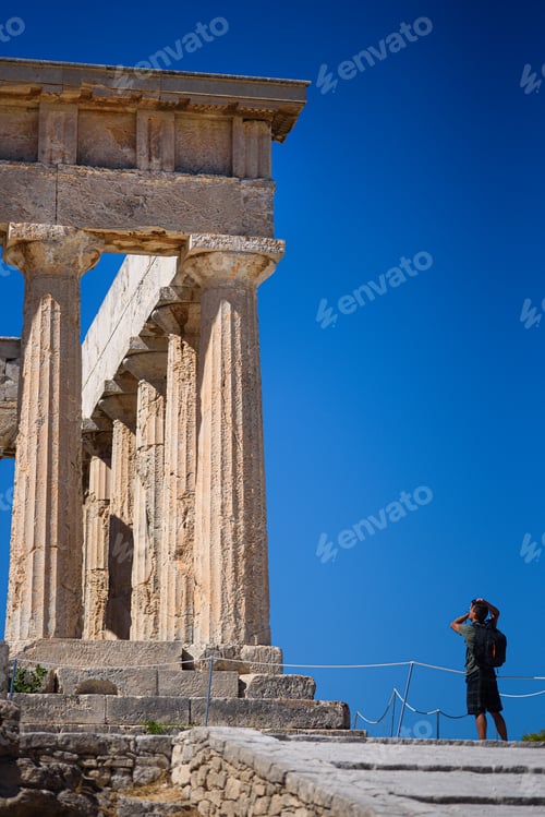 Preview: Tourist exploring ancient Temple of Aphaia columns in Aegina