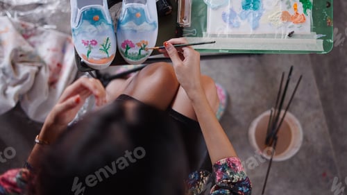 Preview: Person painting abstract flowers on custom blank canvas shoes for expressive fashion