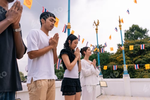 Preview: Young asian people practicing mindfulness, showing devotion and respect at a temple
