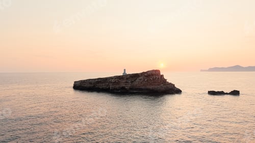 Preview: Lighthouse on a rock island, capturing the calm beauty of an ocean sunset