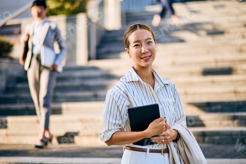 Preview: Confident Asian Businesswoman Smiling in Urban Environment with Sunny Lighting