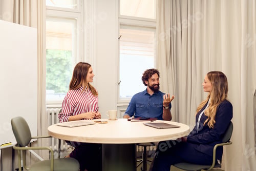 Preview: Business Team Engaged in Collaborative Discussion Around Conference Table