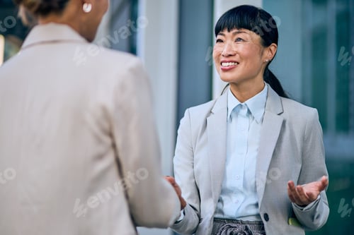 Preview: Confident Asian Businesswoman Engaged in Outdoor Professional Conversation with Colleague