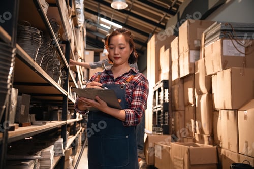 Preview: Inventory worker writing in warehouse aisle