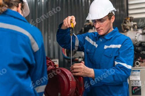 Preview: Factory worker repairing machine in industrial plant