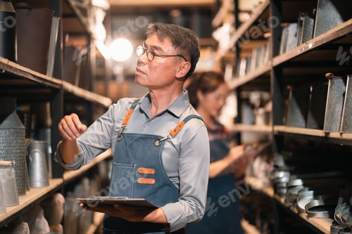 Preview: Shelf worker checking metal container in storage room
