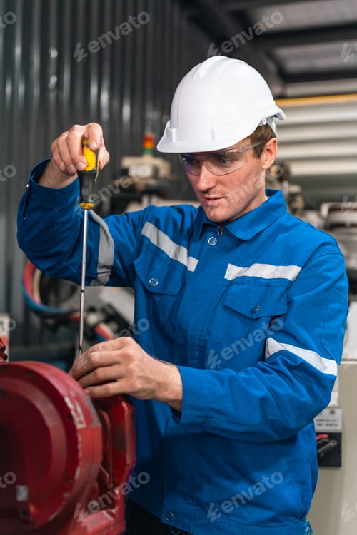 Preview: Industrial worker, blue uniform, safety helmet, safety glasses, screwdriver