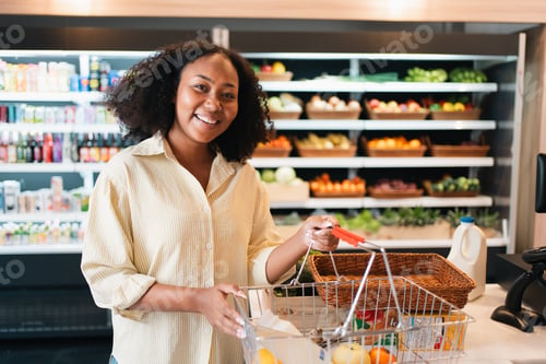 Preview: Woman shopping in grocery store with basket and fresh produce