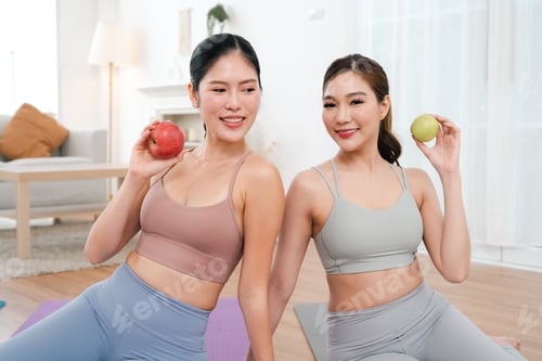 Preview: Healthy woman holding fruit in bright home workout room