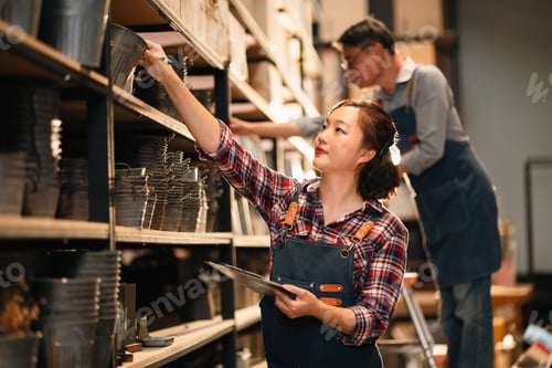Preview: Ceramic workshop shelves with two potter organizing clay bowls