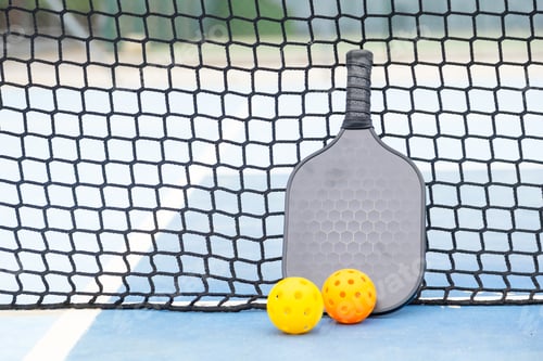 Preview: Pickleball paddle and balls resting on court