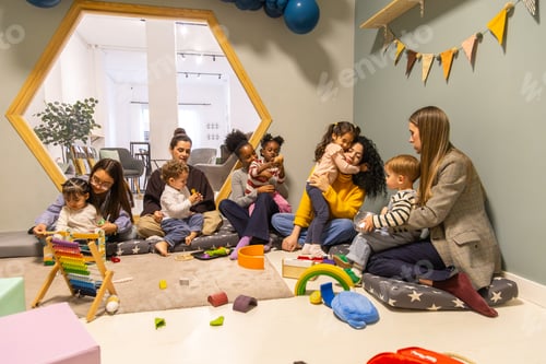 Preview: Diverse parents playing with young children in nursery
