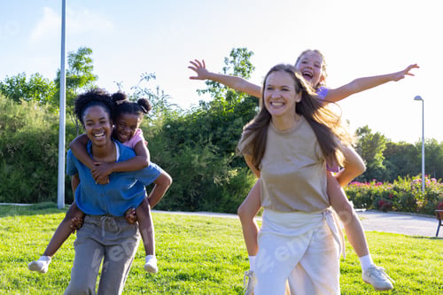 Preview: Diverse mothers giving daughters piggyback rides in park