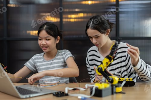 Preview: girls working a robotics project, assembling colorful wires and components, showcasing STEM educatio