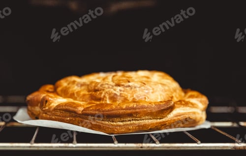 Preview: The Galette des Rois pie rests on a wire rack in a gas oven.