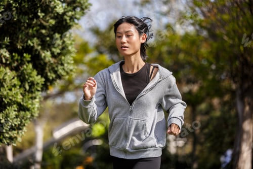 Preview: Young woman exercises in a park in Spain, jogging outdoors in the daytime
