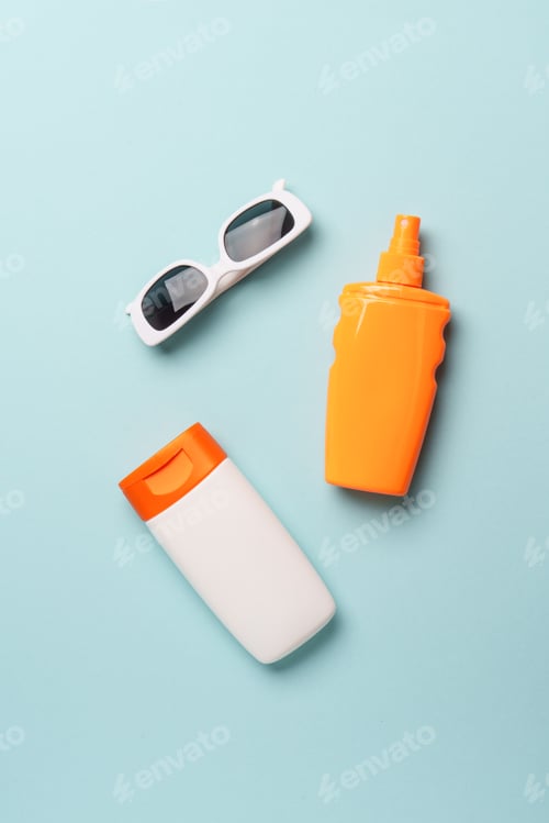 Preview: Sunscreen, sun cream and sunglasses on blue background.