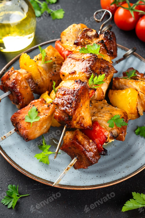 Preview: Grilled shish kebab, Grilled meat skewers with vegetables and herbs on black background.