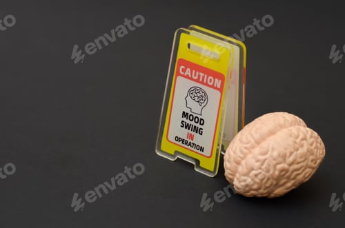 Preview: ental Health Awareness Concept with Human Brain Model and Caution Mood Swing In Operation Sign on Bl