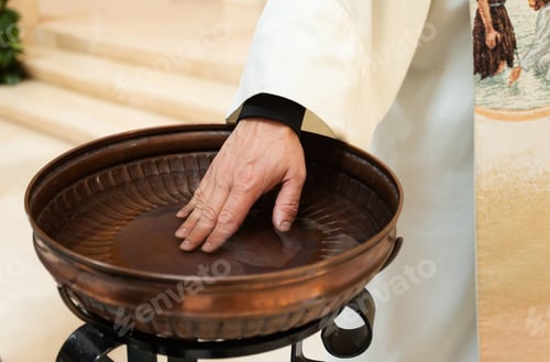 Preview: Priest's hand touching water in baptismal font