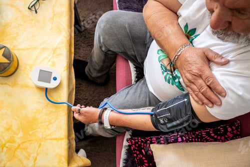 Preview: Senior man monitoring blood pressure at home