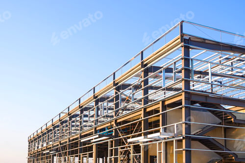 Preview: Steel frame structure of industrial building under construction against blue sky background.