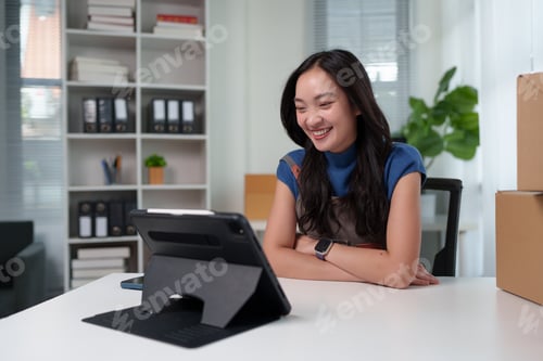 Preview: Young woman smiling during a video call on a tablet
