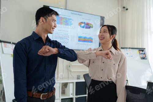 Preview: Asian business team elbow bumping in office greeting