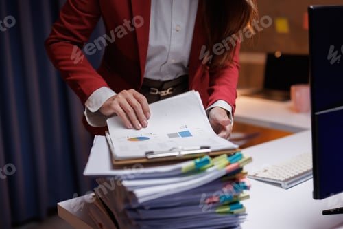 Preview: Professional businessperson organizing financial papers on office desk