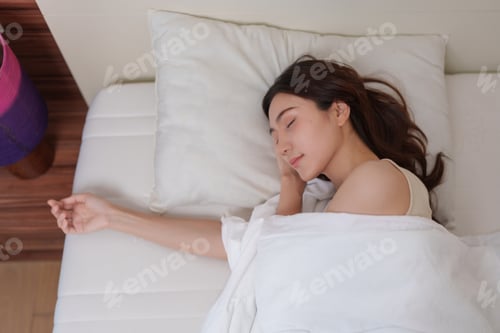 Preview: Young woman sleeping peacefully in white bed